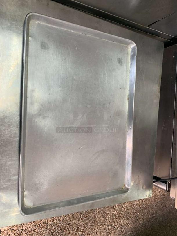 Universal Commercial Grade full-size stainless steel sheet pan, used condition, durable for heavy-duty baking.