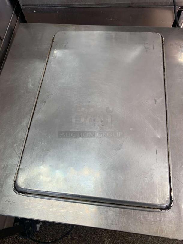 Universal Commercial Grade full-size stainless steel sheet pan, used condition, ideal for baking, minor surface scratches.