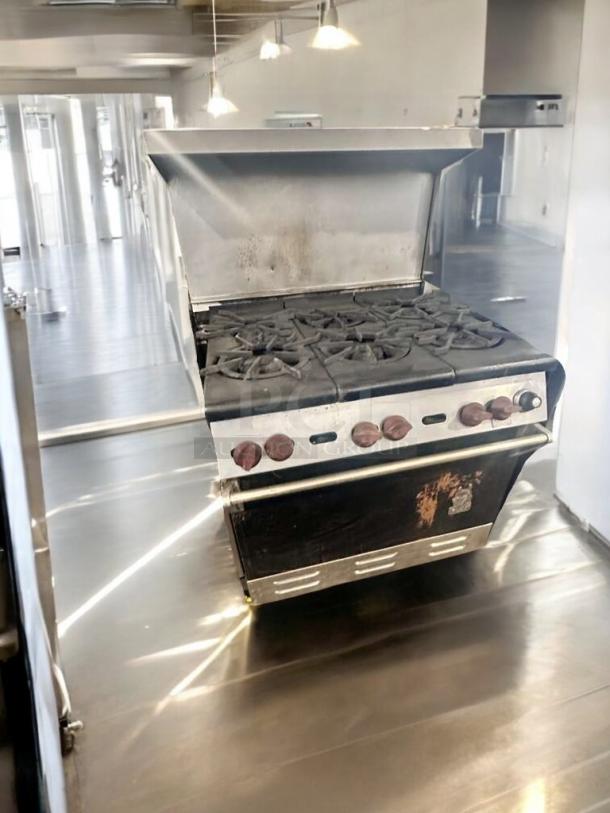 Imperial IR-6 gas range with 6 burners and oven. Natural gas, great condition, fully tested. Some exterior wear visible.