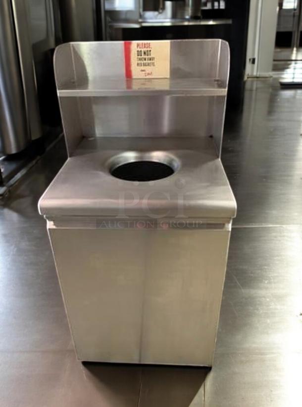 Immaculate stainless steel trash receptacle with top disposal hole and upper shelf. Commercial grade, tested, ready to use.