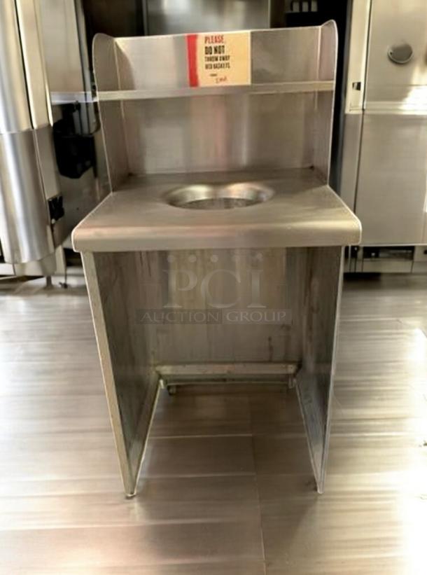 Commercial-grade stainless steel trash receptacle with top disposal hole and upper shelf. Immaculate condition, fully tested.