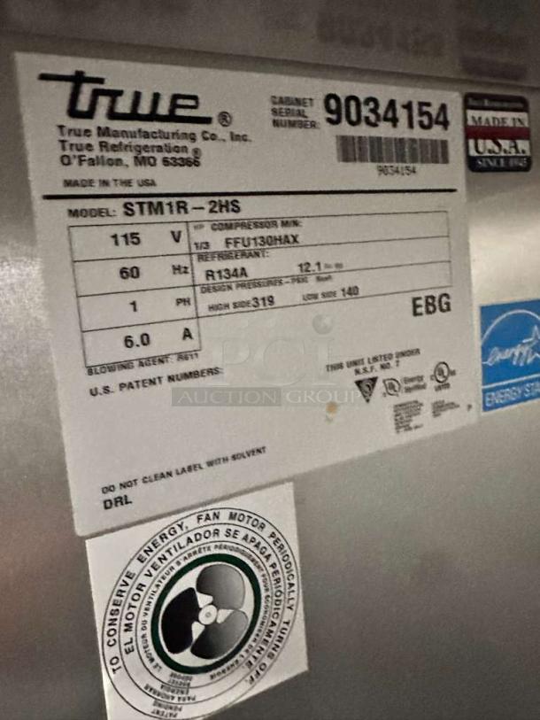 Label on True GDM-43EM display refrigerator. Shows model info, voltage, refrigerant type, and energy conservation details.