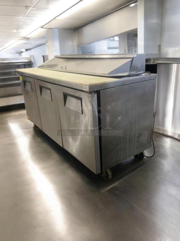 True TSSU-72-18 prep table refrigerator, 72" wide, in outstanding condition. Features three doors, durable stainless steel.
