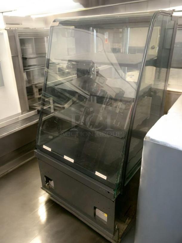 Pristine heated display case with full-view glass in excellent condition, showcasing spacious shelving, fully tested and working.