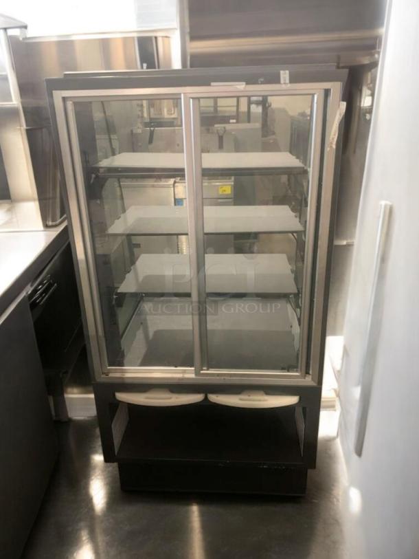 Pristine heated display case, full-view glass, shelves visible. Tested and fully operational, perfect for merchandising.