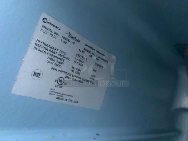 Label inside Delfield 6025XL-S refrigerator showing model, electrical requirements (115V), and refrigerant type (R-404A).