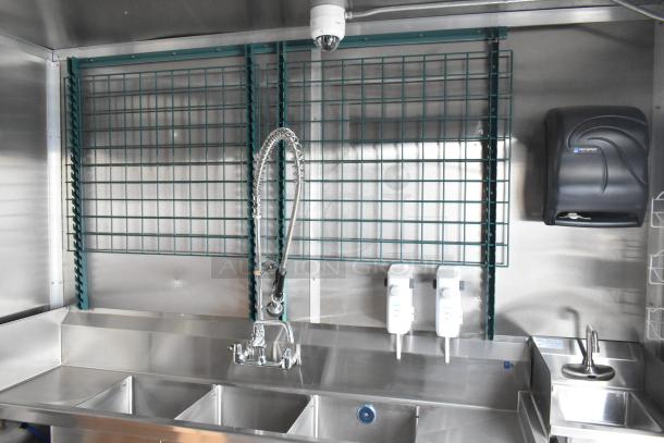 Brand new 2021 food trailer kitchen interior with triple sink, San Jamar paper dispenser, and mounted soap dispensers.