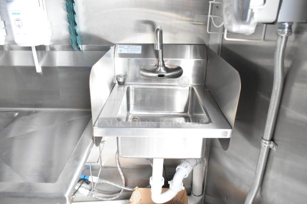 Stainless steel hand sink in new food trailer, featuring modern fixtures and Ecolab dispenser, ideal for commercial use.