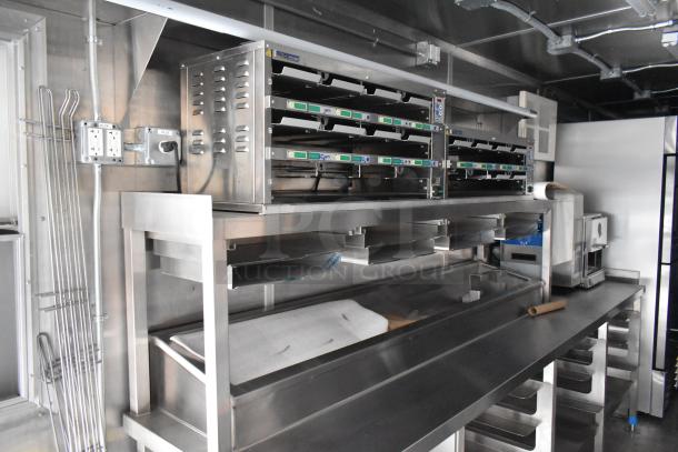 Brand new 2021 food trailer interior with stainless steel counters, CaptiveAire grease hood, True freezers, and cooler.