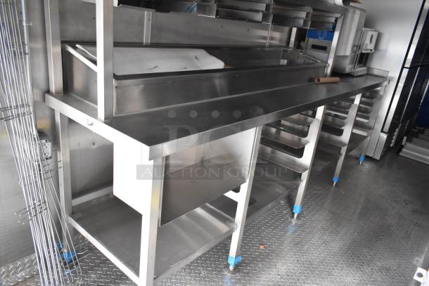 Brand new 2021 food trailer kitchen with stainless steel prep tables, CaptiveAire grease hood, True freezers, and cooler.