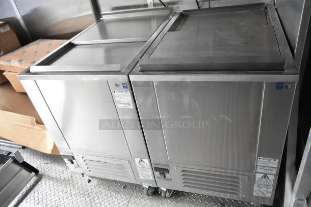 Brand new food trailer interior featuring stainless steel True freezers. Labels show electrical testing. Ideal for mobile kitchen.