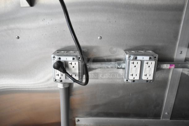 Electrical outlets inside a brand new 2021 food trailer, showing two outlet boxes with GFCI protection and labeled switches.