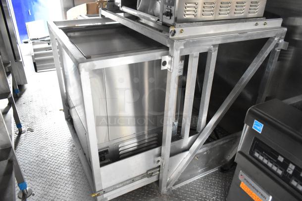Brand new 2021 food trailer interior with stainless steel equipment, CaptiveAire grease hood, and True freezers.
