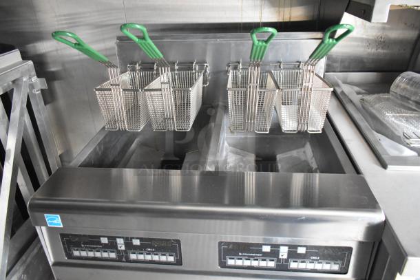 Fully outfitted 2021 food trailer kitchen with CaptiveAire grease hood, fryers, True freezers, cooler, and French fry freezers.