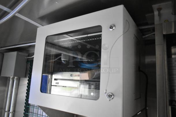 Inside look of a brand new food trailer kitchen appliance setup featuring a CaptiveAire grease hood.