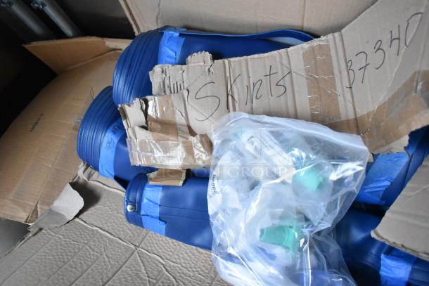 Cardboard box labeled "Skirts" with blue rolled items and packaged small parts. Packaging looks intact.