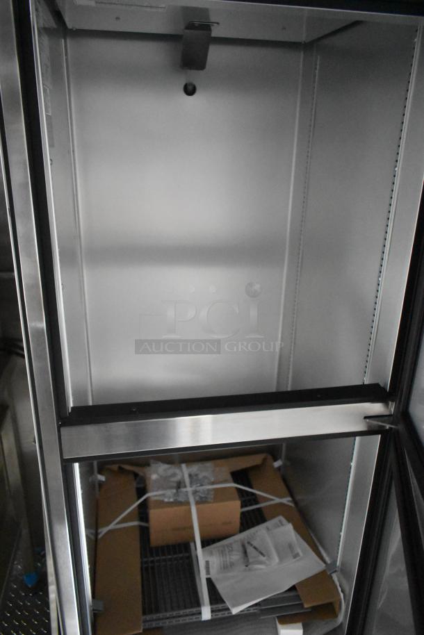 Brand new 2021 food trailer interior showing sleek stainless steel shelving with packaging and documents. Perfect for mobile kitchen setups.