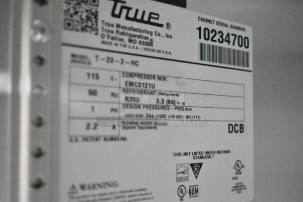 True Refrigeration label on a food trailer appliance, showing model T-23-2-HC, compressor EMC3121U, uses R290 refrigerant.