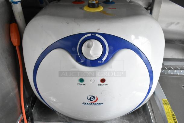 Eccotemp water heater in food trailer, featuring power and heating indicators, adjustable temperature dial, white and blue design.