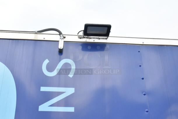 Blue food trailer exterior with mounted floodlight. Features large text "S". Ideal for mobile kitchen use.