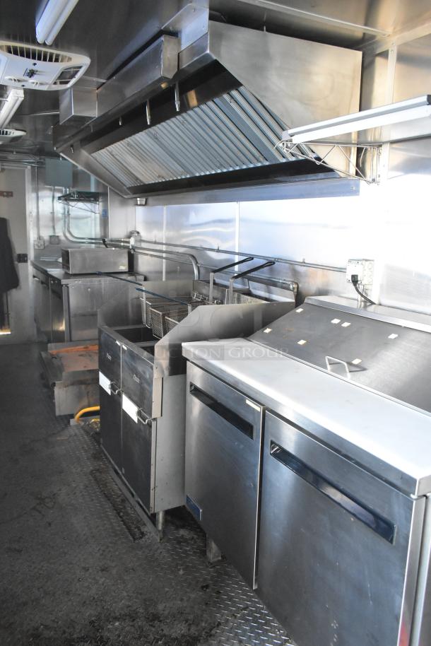 Brand new 2021 food trailer with CaptiveAire hood, True freezers, cooler, fryers, holding bins, and sinks in pristine condition.