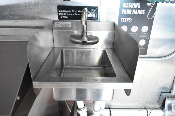 Stainless steel hand sink with sensor faucet in a food trailer, tagged "MRS-HS-14." Employee handwashing sign visible.