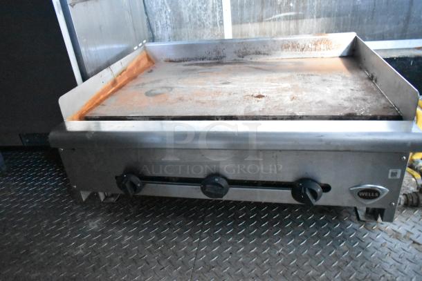 Wells commercial griddle with rust on surface, equipped with black temperature knobs, ideal for mobile kitchens.