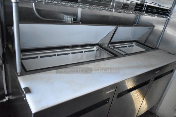 Fully equipped food trailer with commercial-grade appliances: CaptiveAire grease hood, 3 True freezers, True cooler, and French fry freezers.