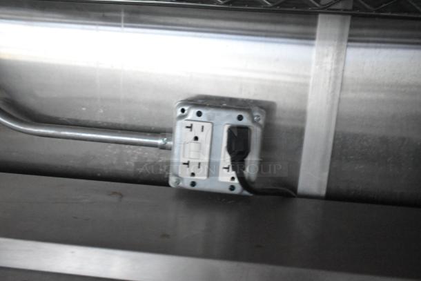 Electrical outlet inside a food trailer, showcasing GFCI protection. Part of a commercially equipped mobile kitchen.