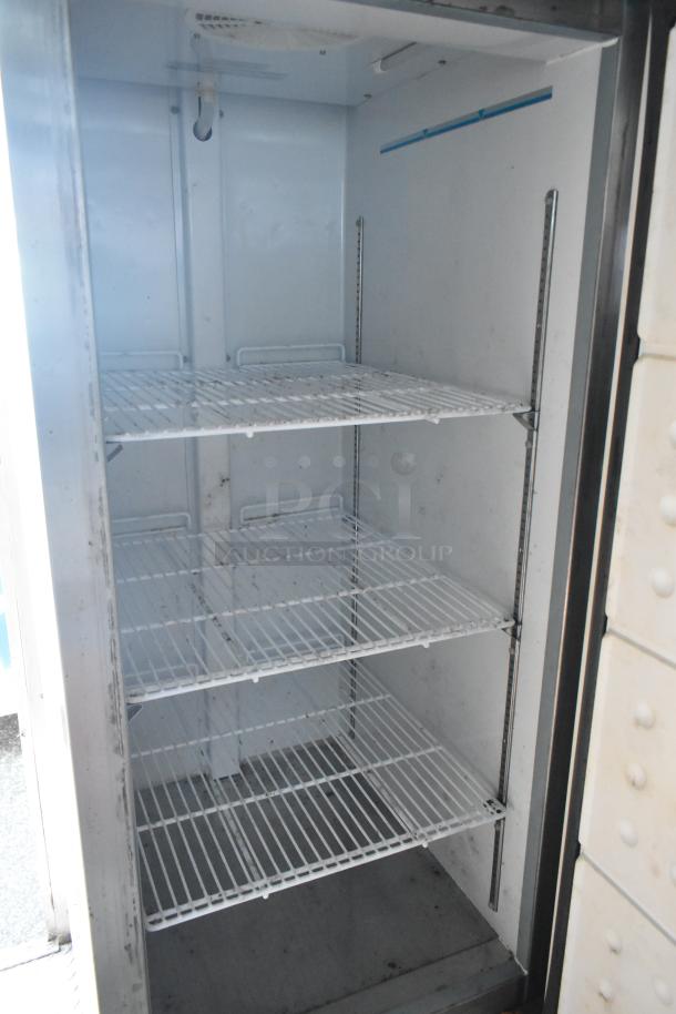 Interior view of commercial-grade True freezer with four wire shelves, showcasing ample storage space. Brand new condition.