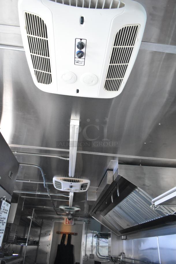 Interior of a fully equipped food trailer featuring a CaptiveAire grease hood and ventilation system in pristine condition.