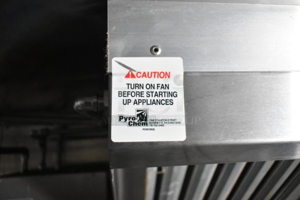 Caution label on PyroChem equipment in a fully equipped 2021 food trailer. Advises fan activation before using appliances.