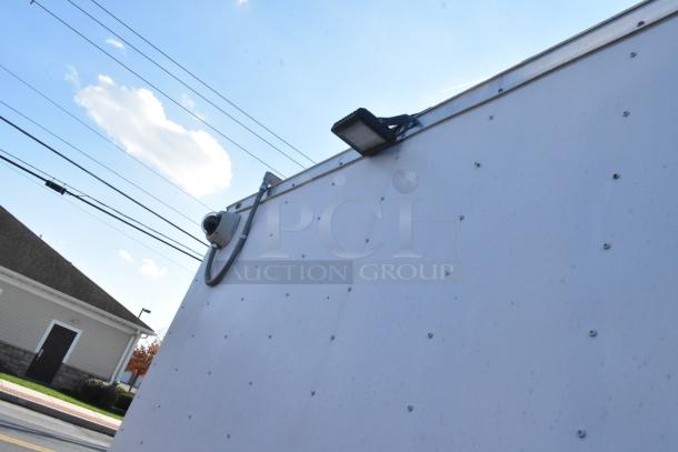 Exterior view of a brand new 2021 food trailer featuring security camera and lighting on the roof.