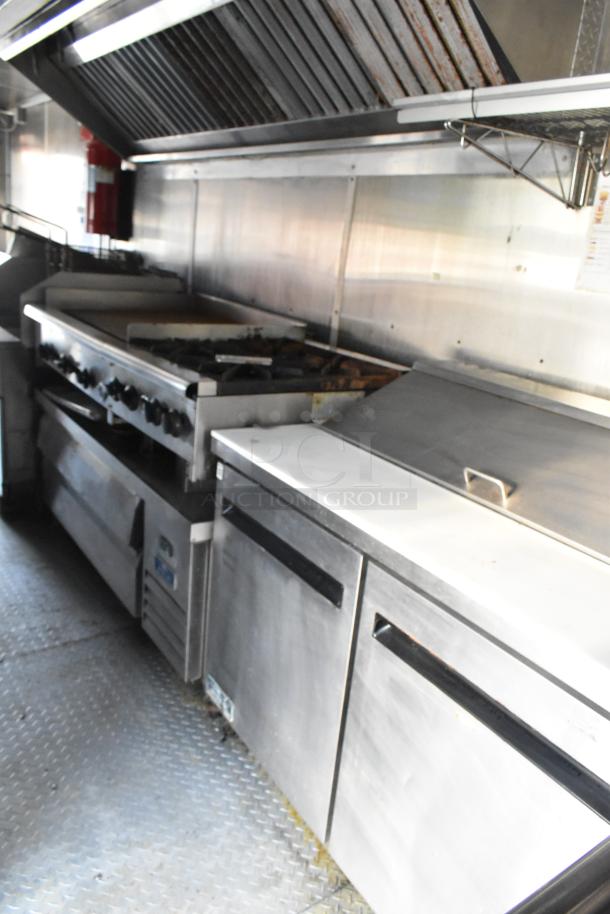 Fully equipped food trailer kitchen with commercial-grade appliances, including Pyrochem hood, Arctic Air coolers, and Wells range.