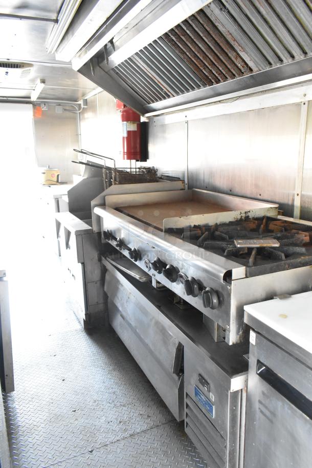 Fully outfitted food trailer interior with commercial appliances: Pyrochem hood, Wells range, Pitco fryer, Arctic Air units.
