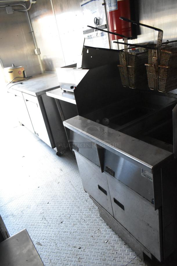 Fully equipped food trailer interior with stainless steel Pitco Frialator gas fryer, Arctic Air coolers, prep tables, and commercial fixtures.