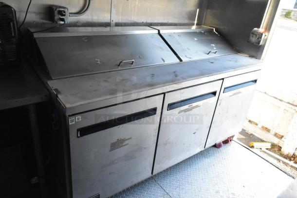 Industrial-grade Arctic Air prep table with stainless steel finish and covered storage, suitable for food trailer use.