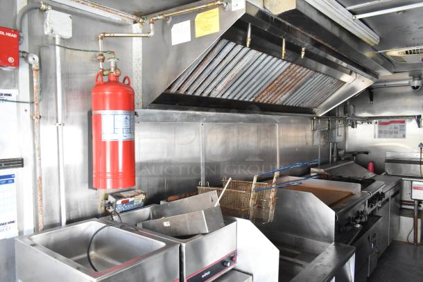 Fully equipped food trailer kitchen with Pyrochem hood, Arctic Air coolers, Pitco fryer, and more commercial-grade appliances.