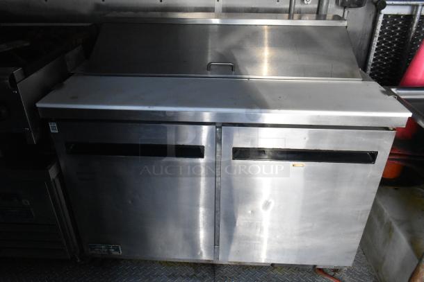 Stainless steel Arctic Air prep table in a food trailer, featuring dual doors and a countertop. Suitable for commercial use.