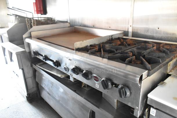 Fully outfitted food trailer with Wells range, flat top, Pitco gas fryer, and Pyrochem hood system; ready for use.