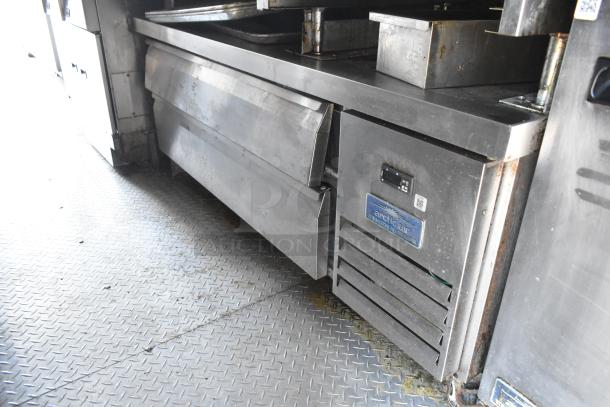 Stainless steel Arctic Air commercial refrigerator in a food trailer kitchen, featuring durable design and storage space.