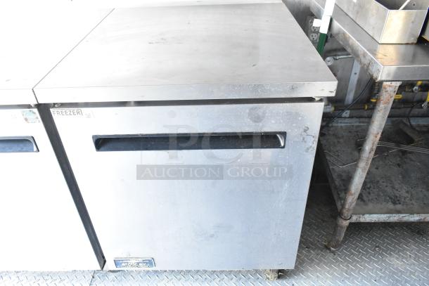 Commercial-grade Arctic Air freezer unit with stainless steel exterior, part of a fully equipped food trailer kitchen.