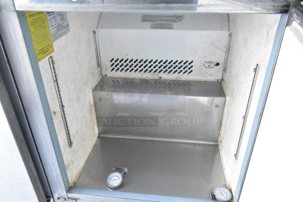 Interior of food trailer showing stainless steel compartment with temperature gauges. Labels detail appliance specifications.
