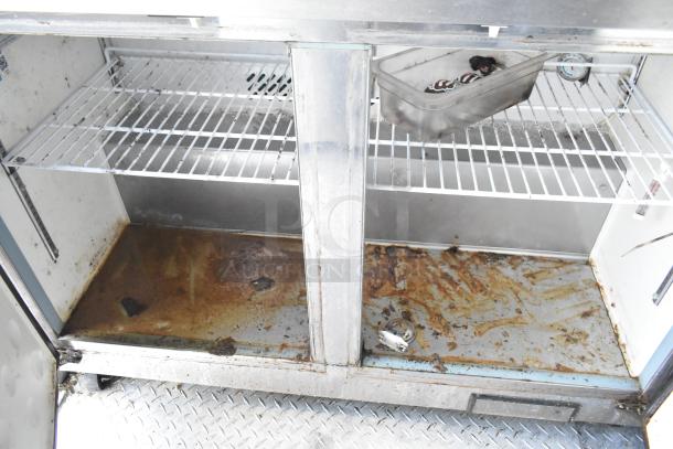Inside view of a commercial fridge with rusted shelves in a food trailer, showing wear and maintenance needs.