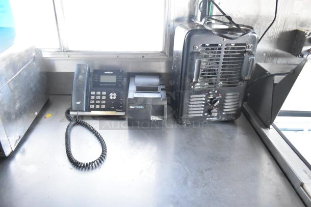 Mobile kitchen interior showing a Verizon Yealink phone, Star Micronics receipt printer, and industrial heater on a countertop.