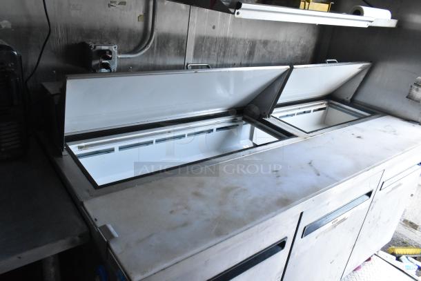Stainless steel Arctic Air prep table in a new food trailer, featuring dual compartments and sturdy construction for commercial use.