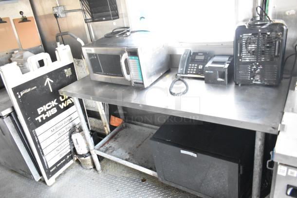 Fully outfitted food trailer interior, featuring a commercial microwave, phone, printer, and signage. Ideal for a ghost kitchen.