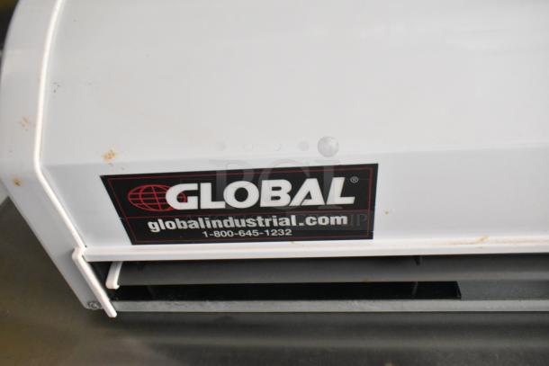 Global Industrial equipment label on a commercial appliance in a fully equipped food trailer, featuring a contact number.