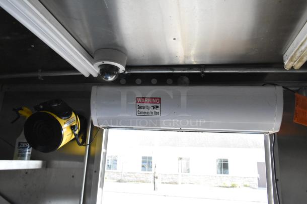 Interior of a new food trailer with security camera and warning sign, featuring Arctic Air and Wells equipment.