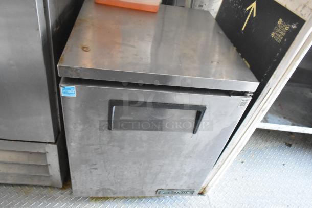 Stainless steel Arctic Air cooler from a food trailer setup, featuring a top handle and manufacturer logo.
